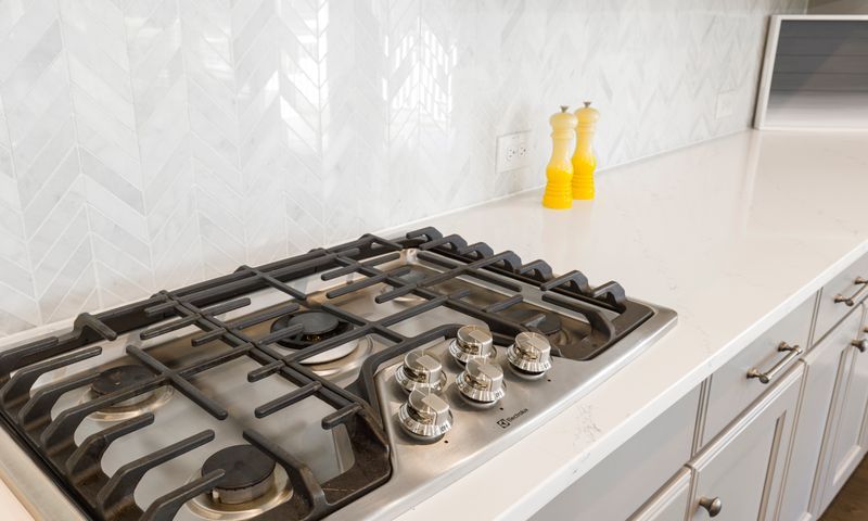 Cooktop a gás de cinco bocas em cozinha branca, serviço de conserto de fogão em Sorocaba